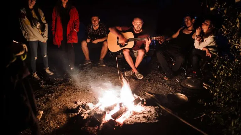 Gruppe mit Gitarre am Lagerfeuer